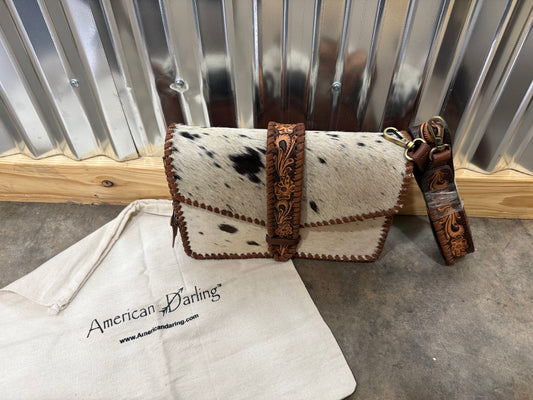 Hair-on cowhide crossbody bag with tooled leather strap and trim