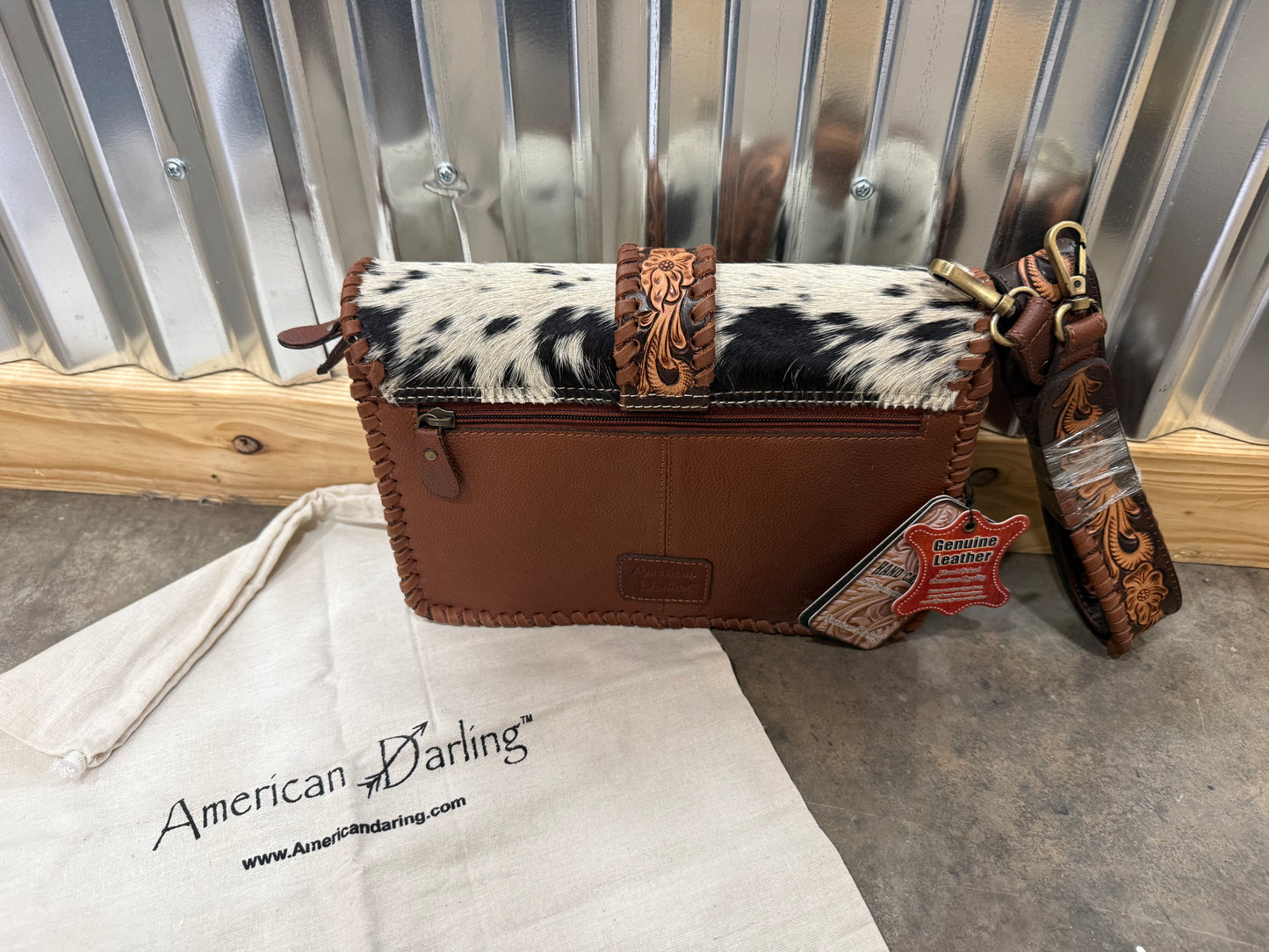 Hair-on cowhide crossbody bag with tooled leather strap and trim
