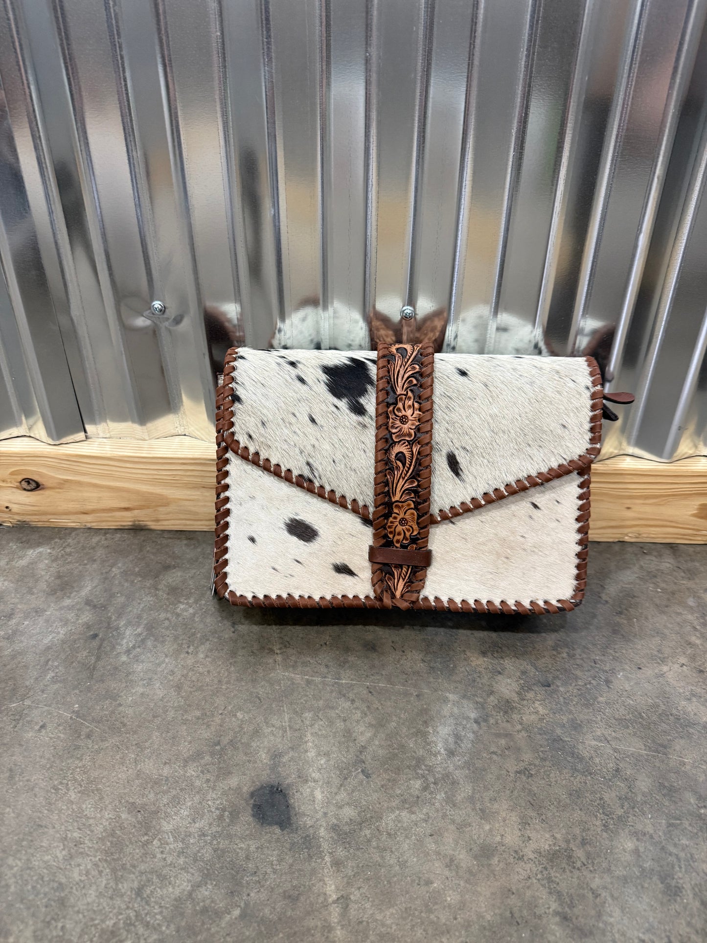 Hair-on cowhide crossbody bag with tooled leather strap and trim